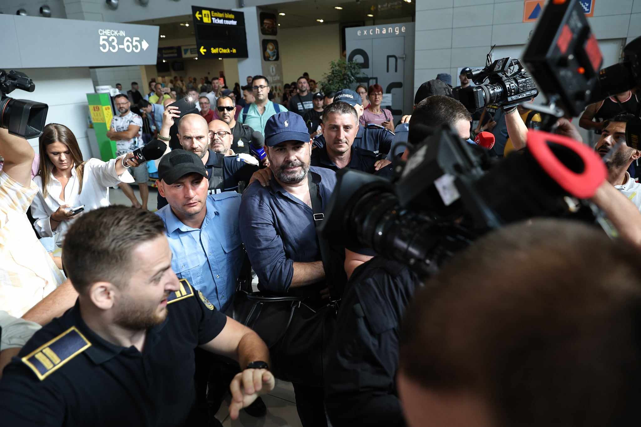 Darius Vâlcov, extrădat din Italia: flancat de jandarmi pe Otopeni, până la mașina care l-a dus la penitenciar. Are de ispășit o pedeapsă de 6 ani de închisoare