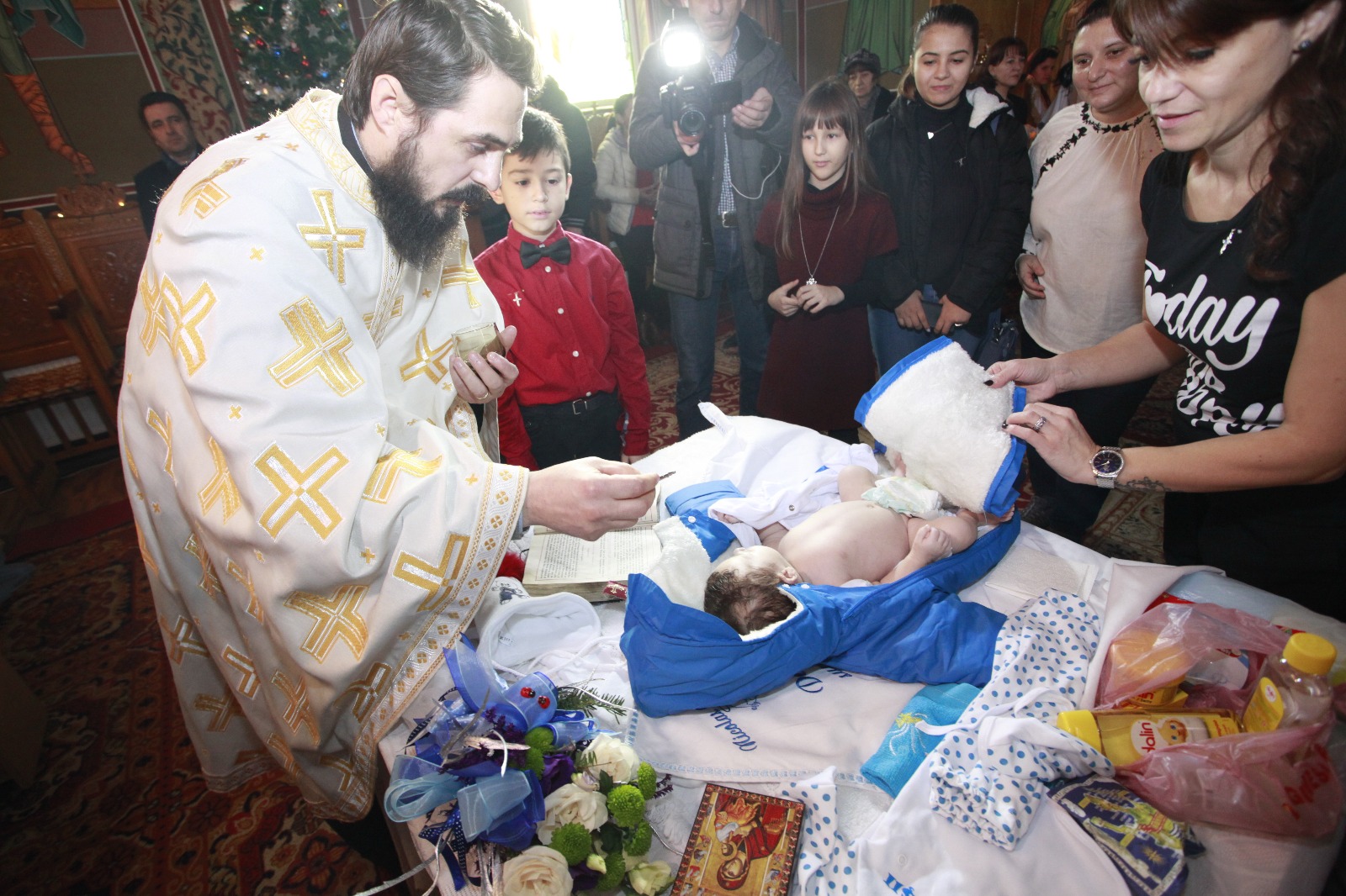 FOTO-REPORTAJ: Abandonat de mamă, s-a ales cu zeci de părinți spirituali. Bebelușul lăsat în ger a fost botezat