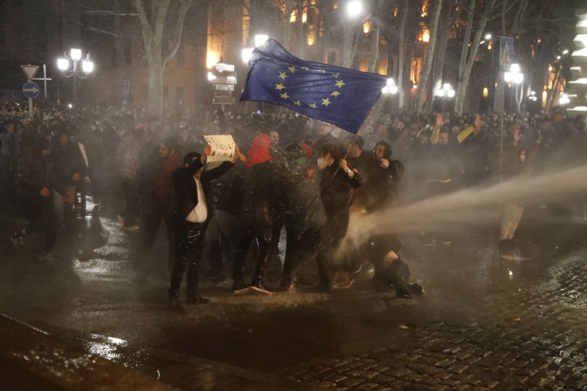 Imagine simbolică pentru 2023, la protestele din Georgia: manifestanți strânși în jurul steagului UE, fluturat de o femeie pe care autoritățile au pus tunul cu apă - VIDEO