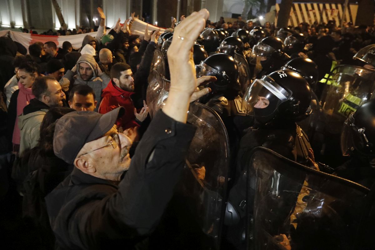 Imagine simbolică pentru 2023, la protestele din Georgia: manifestanți strânși în jurul steagului UE, fluturat de o femeie pe care autoritățile au pus tunul cu apă - VIDEO