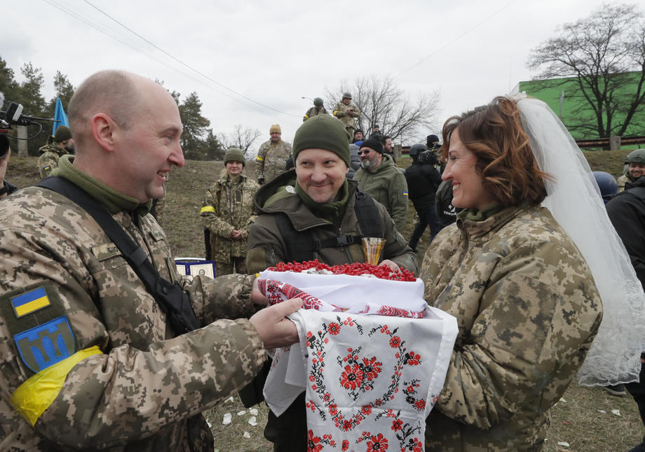 Nuntă pe front. În haine de camuflaj, cu alai înarmat cu flori și puști, doi militari ucraineni s-au căsătorit