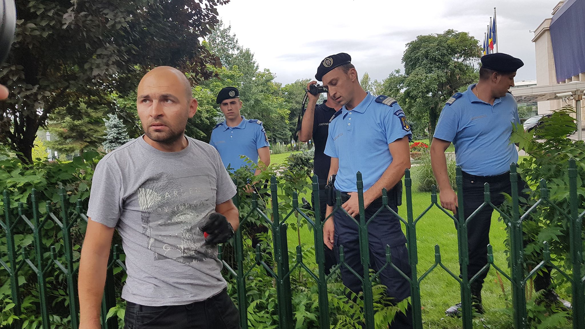 UPDATE. Bărbatul care s-a legat cu lanțul de gardul Guvernului și avea asupra lui o sticlă de benzină a fost descarcerat si ridicat de Jandarmerie (FOTO / VIDEO)