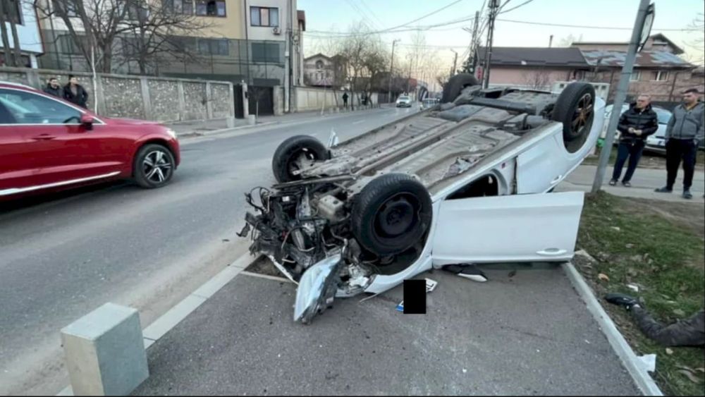 Momentul în care o mașină scăpată de sub control spulberă doi oameni pe trotuar, dărâmă stâlpișorii și se răstoarnă, în Chiajna