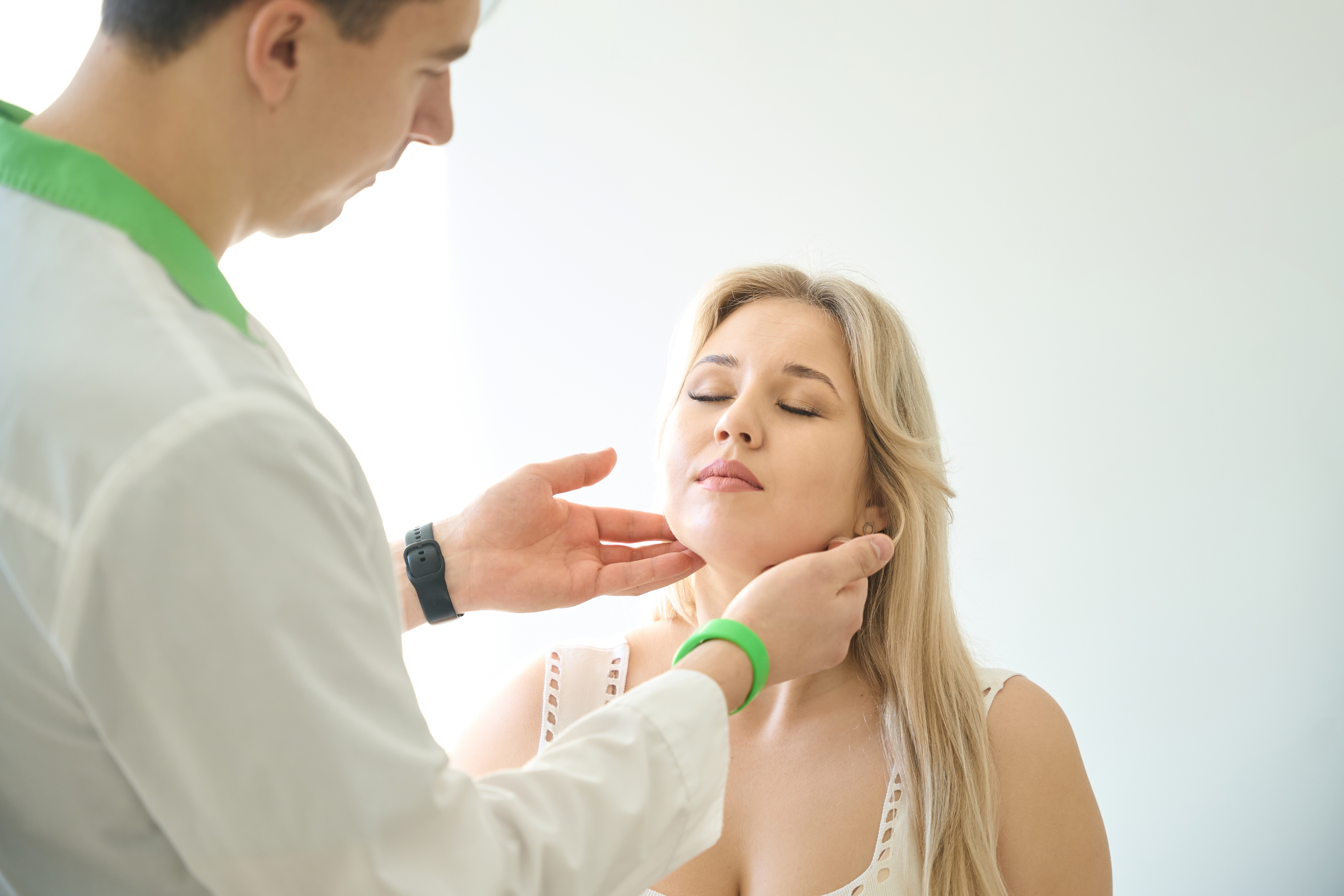 Doctor examining neck and salivary gland swelling
