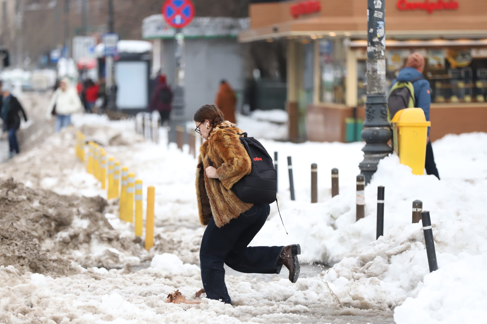 Trotuarele din București, blocate de nămeți și bălți. Oamenii fac slalom printre troiene