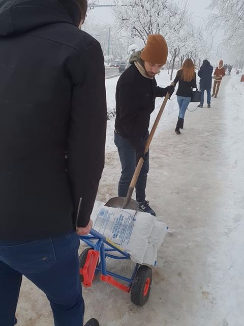 FOTO/ Studenții au ieșit să deszăpezească un trotuar de pe un bulevard din Timișoara pentru că s-au săturat să aștepte Primăria. Robu spune că s-a făcut "tot ce era omenește posibil"