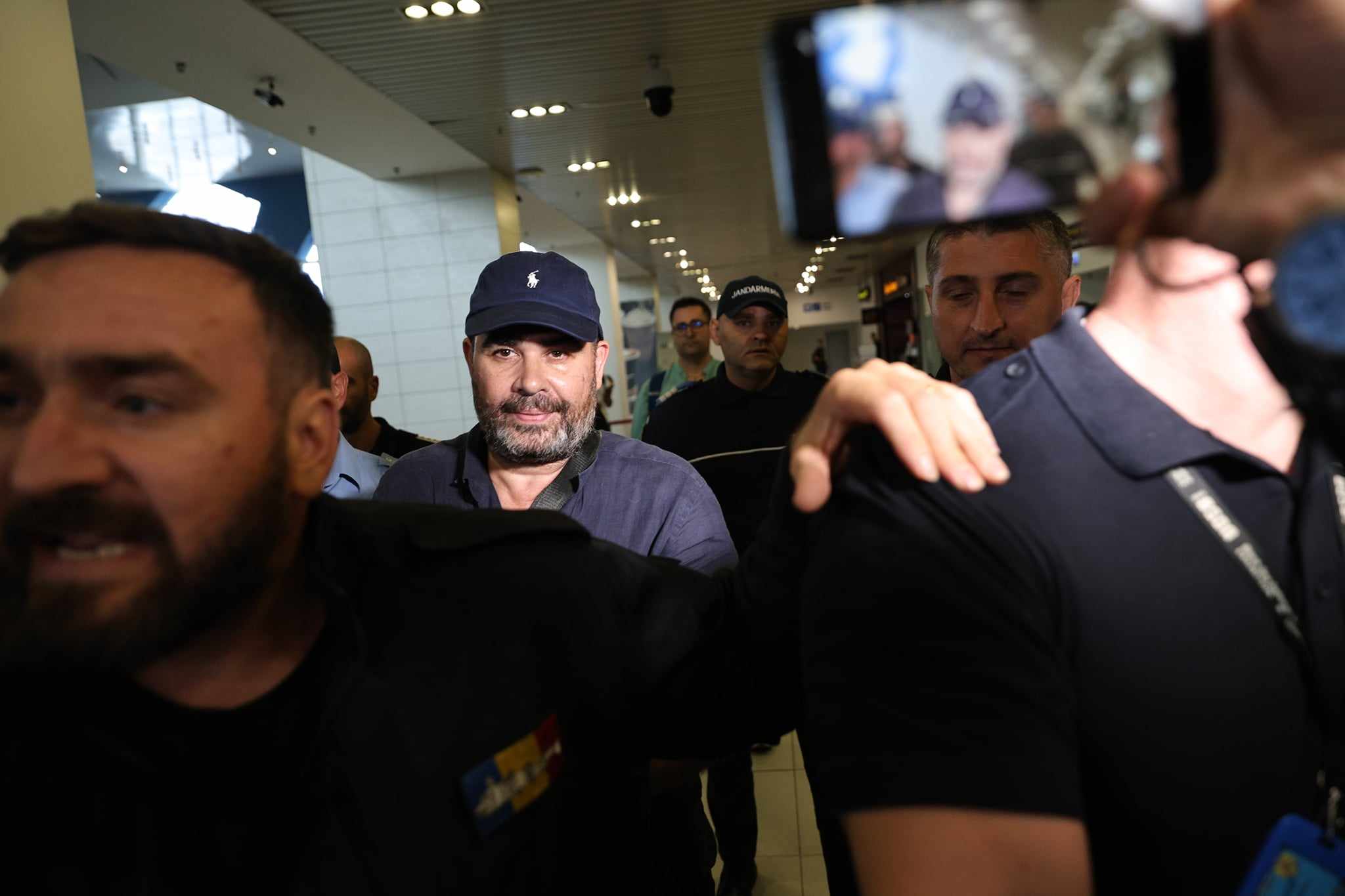 Darius Vâlcov, extrădat din Italia: flancat de jandarmi pe Otopeni, până la mașina care l-a dus la penitenciar. Are de ispășit o pedeapsă de 6 ani de închisoare
