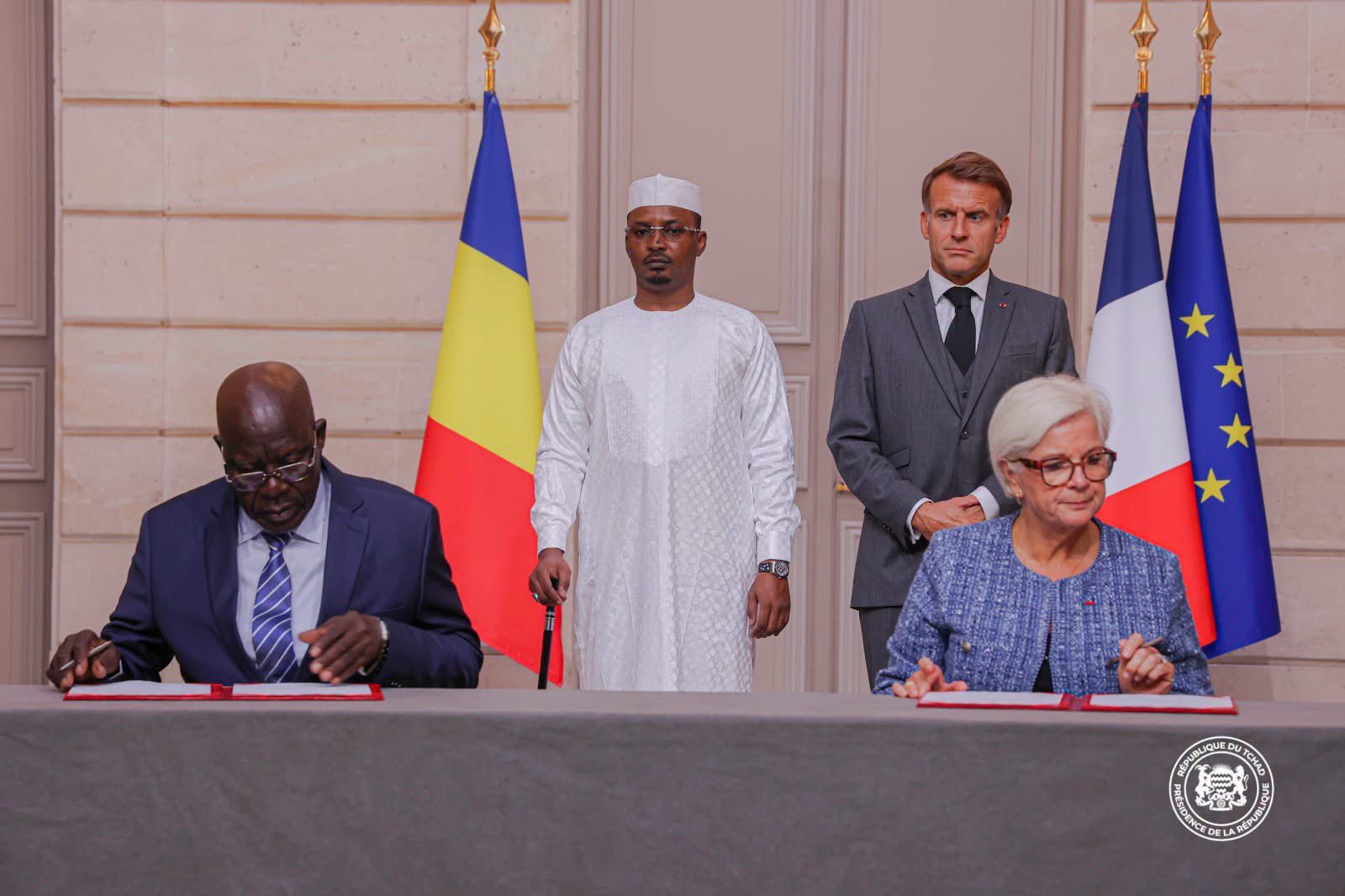 French President Emmanuel Macron and Chadian President Mahamat Idriss Déby watch as Chadian Defence Minister General Issakha Malloua Djamouss and French Defence Minister Catherine Vautrin sign an agreement at the Élysée Palace on 13 October. [The Presidency]