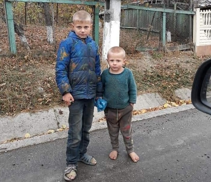 REPORTAJ/ Povestea din spatele unei fotografii virale: doi copii în picioarele goale pe stradă, în prag de iarnă. Zece suflete înghesuite într-o căsuță și lecția de demnitate cu care-și înfruntă soarta