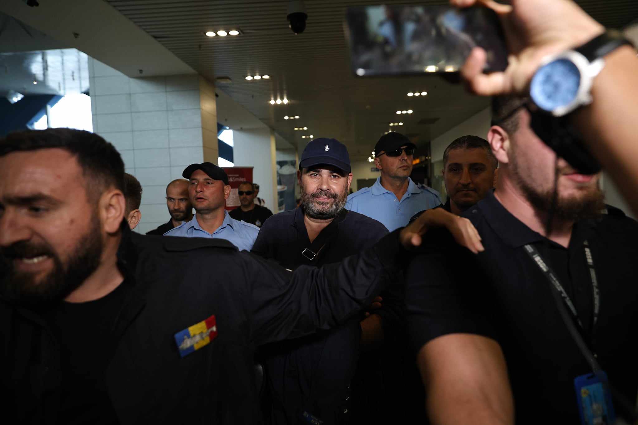 Darius Vâlcov, extrădat din Italia: flancat de jandarmi pe Otopeni, până la mașina care l-a dus la penitenciar. Are de ispășit o pedeapsă de 6 ani de închisoare
