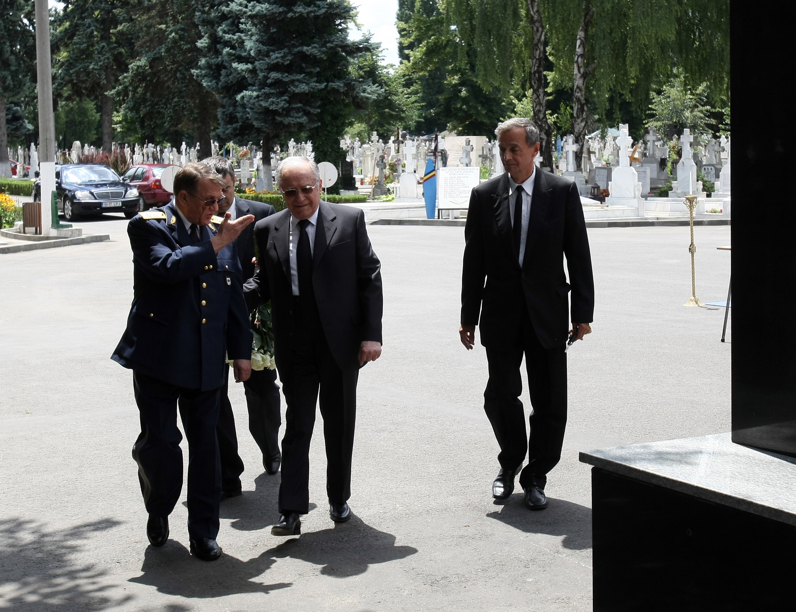 Trei coroane, flori și puține lumânări la mormântul lui nea Angelo