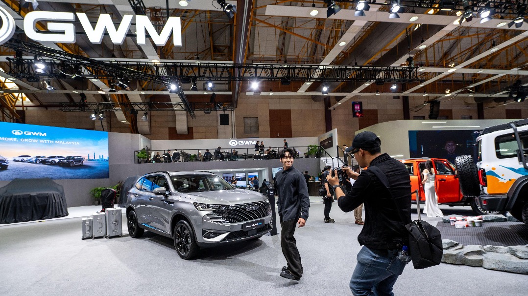 A man poses for a photo at the media preview of the 2025 Malaysia Auto Show on May 8. [Photo/Xinhua]