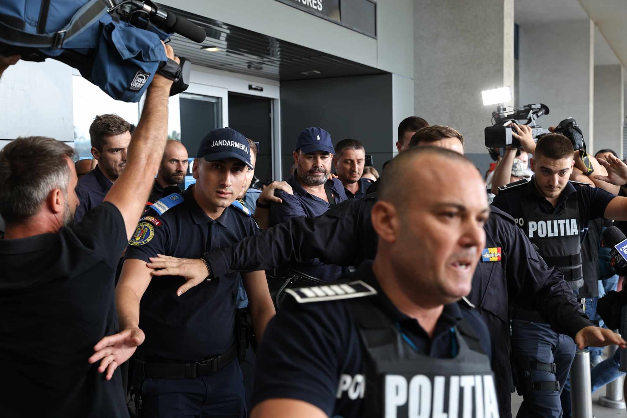 Darius Vâlcov, extrădat din Italia: flancat de jandarmi pe Otopeni, până la mașina care l-a dus la penitenciar. Are de ispășit o pedeapsă de 6 ani de închisoare