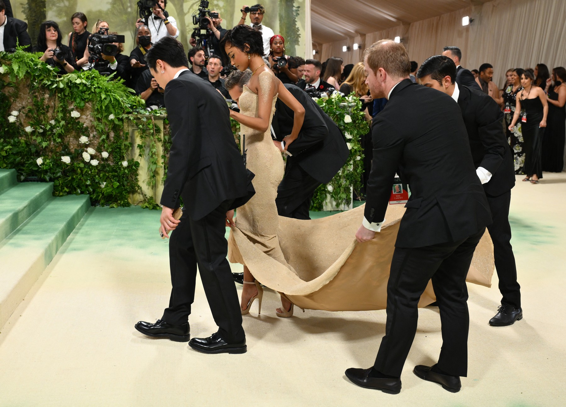 Rochia acoperită în totalitate de nisip purtată de Tyla la Met Gala 2024. Ținuta a împiedicat-o să meargă, iar cinci bărbați au purtat-o pe brațe