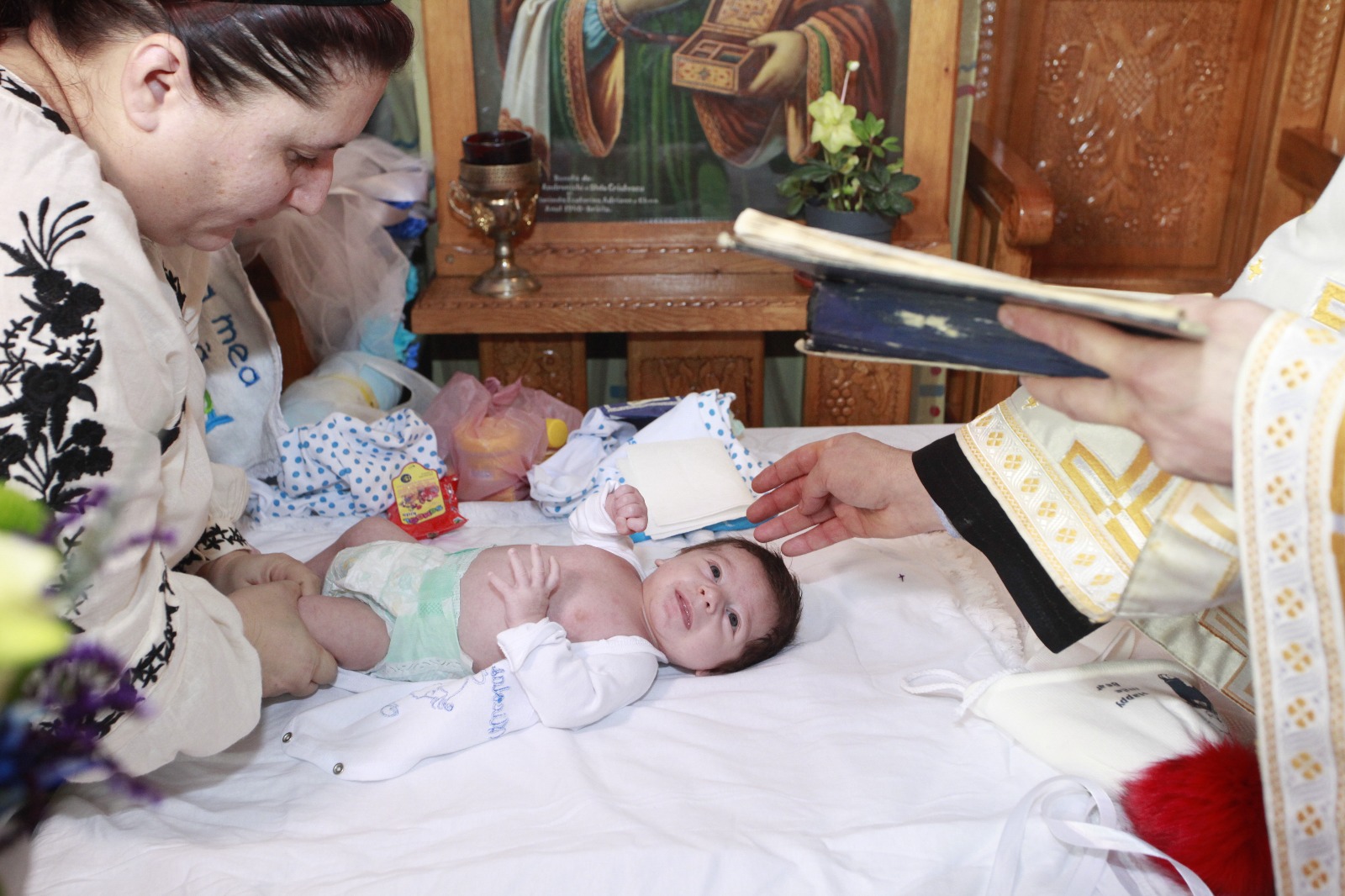 FOTO-REPORTAJ: Abandonat de mamă, s-a ales cu zeci de părinți spirituali. Bebelușul lăsat în ger a fost botezat