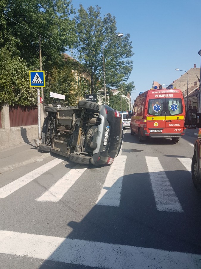FOTO | Accident spectaculos în centrul Sibiului. Două mașini s-au tamponat, iar una s-a răsturnat. Doi copii, printre răniți