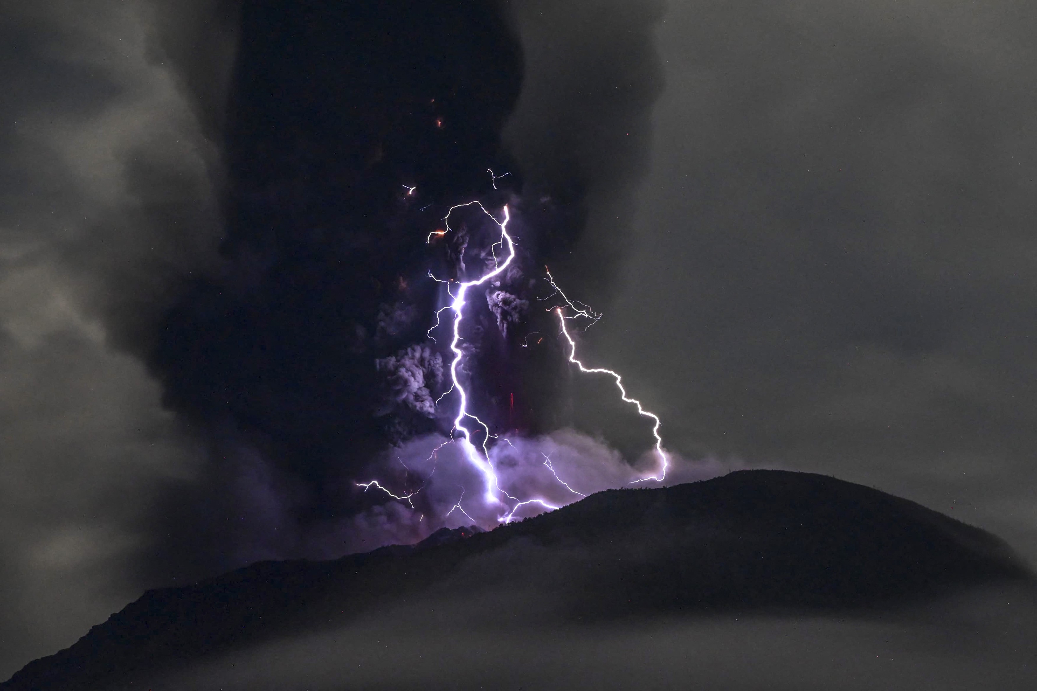 Erupție spectaculoasă a vulcanului Ibu din Indonezia. Fulgere violet în jurul craterului și coloane de cenușă ce se ridică la peste 4 km