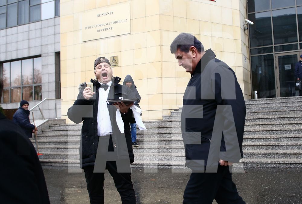 FOTO EXCLUSIV | Gabriel Oprea, întâmpinat cu cătușe pe tavă, la Tribunalul București, de către un protestatar #Rezist costumat în ospătar