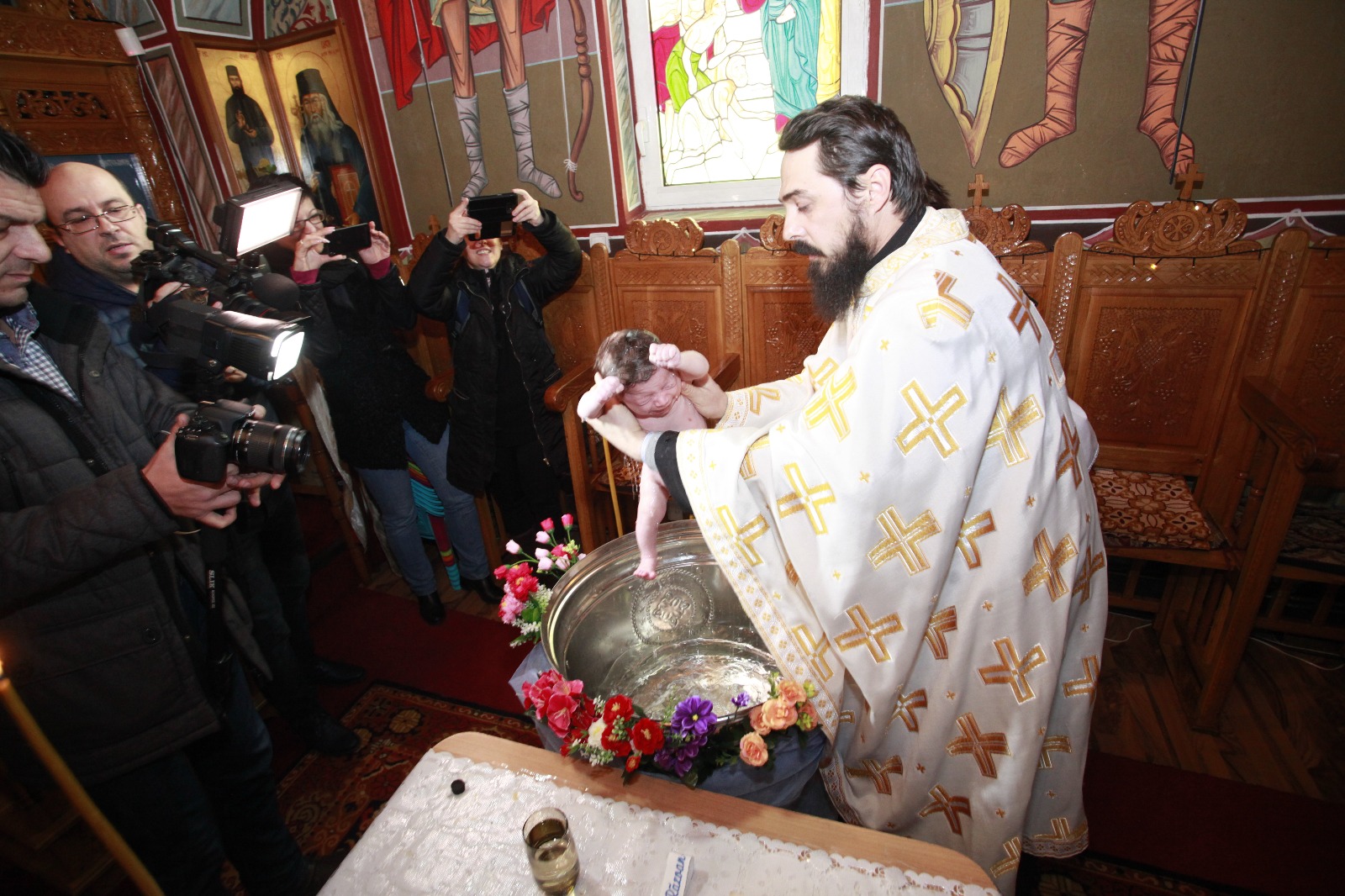 FOTO-REPORTAJ: Abandonat de mamă, s-a ales cu zeci de părinți spirituali. Bebelușul lăsat în ger a fost botezat