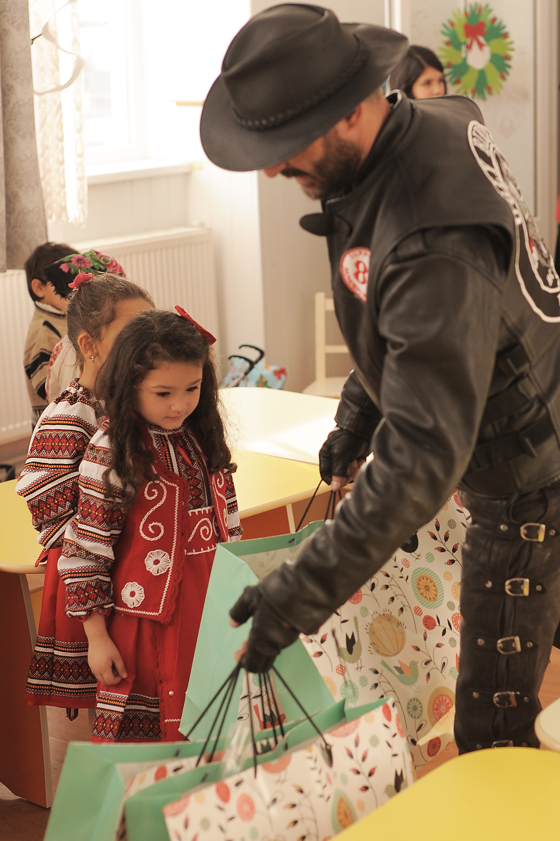 GALERIE FOTO/ Un club de motociclişti a donat calculatoare copiilor dintr-un sat braşovean. Copiii i-au așteptat pe "Ugly Bikers" în costume tradiționale