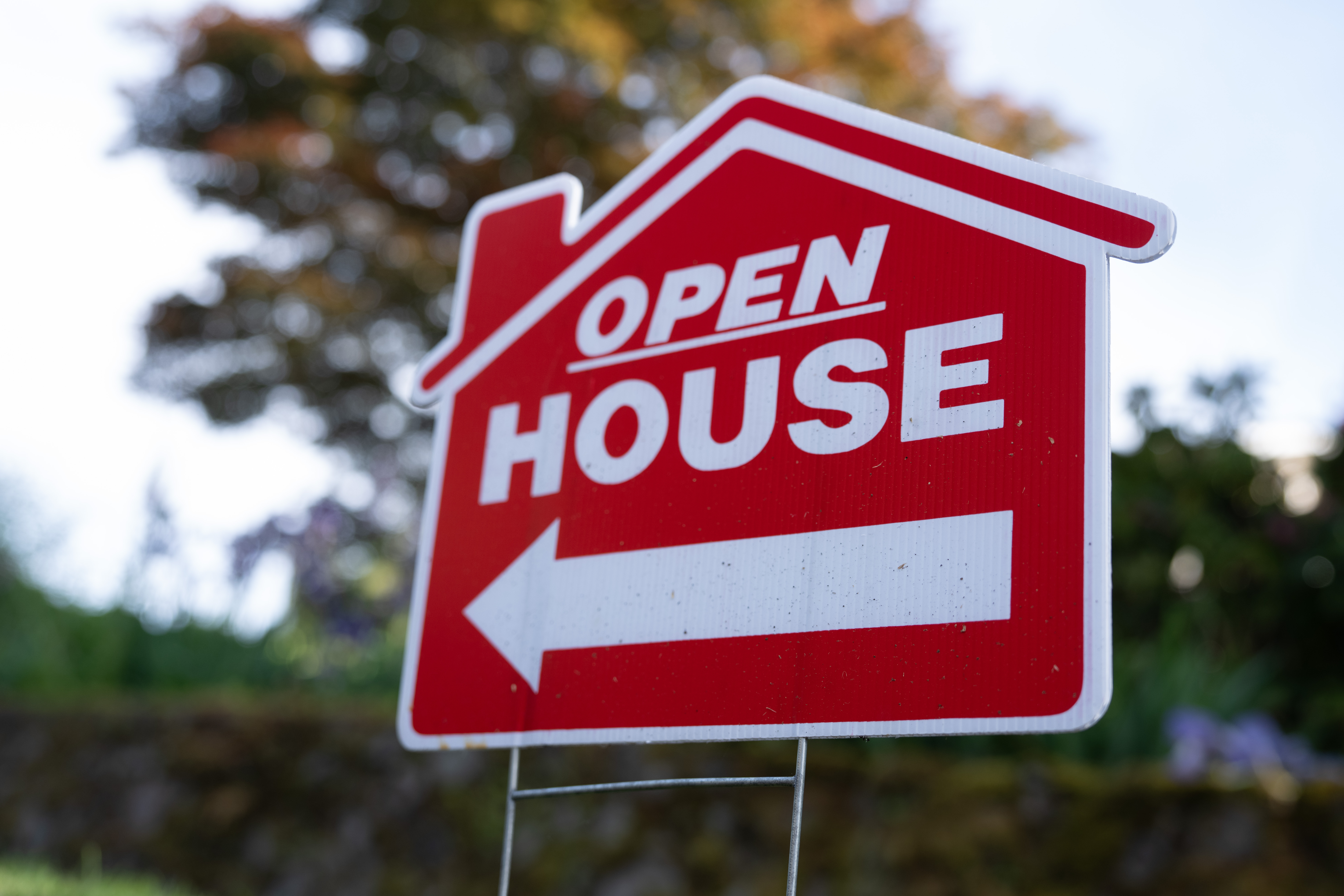 A sign is displayed outside a home for sale.