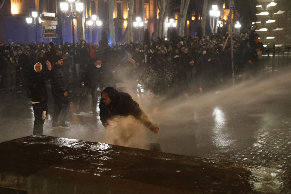 Imagine simbolică pentru 2023, la protestele din Georgia: manifestanți strânși în jurul steagului UE, fluturat de o femeie pe care autoritățile au pus tunul cu apă - VIDEO