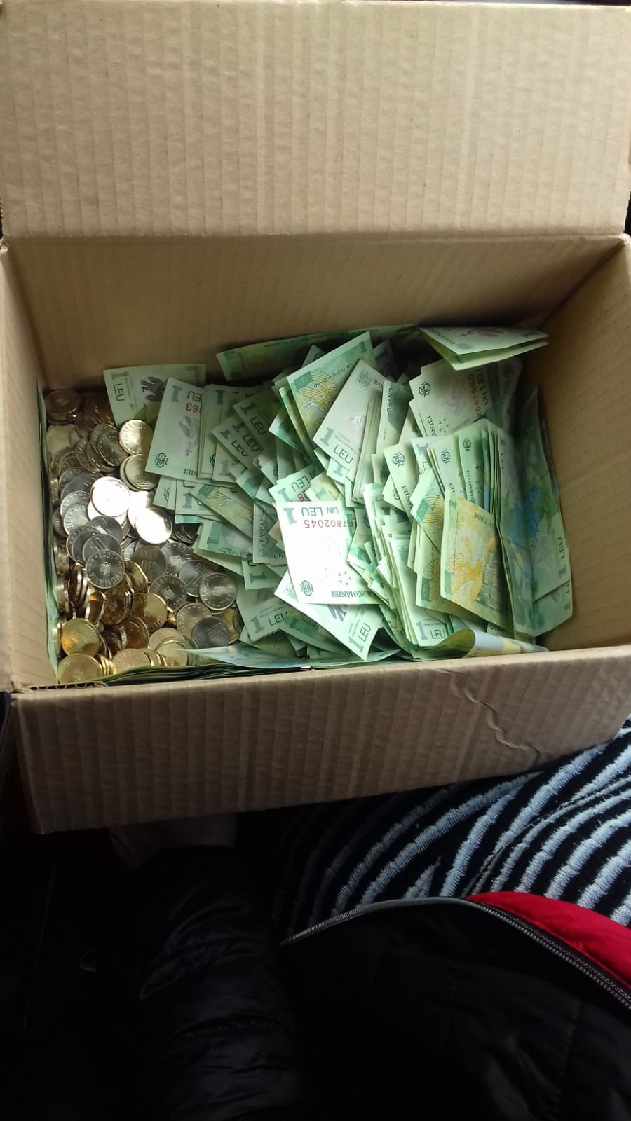 Un șofer român de TIR și-a primit salariul în cutii de carton, în monede de 50 de bani și bancnote de un leu