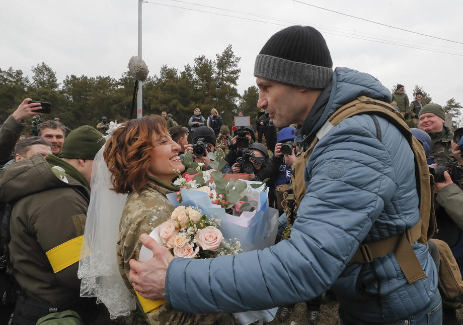 Nuntă pe front. În haine de camuflaj, cu alai înarmat cu flori și puști, doi militari ucraineni s-au căsătorit