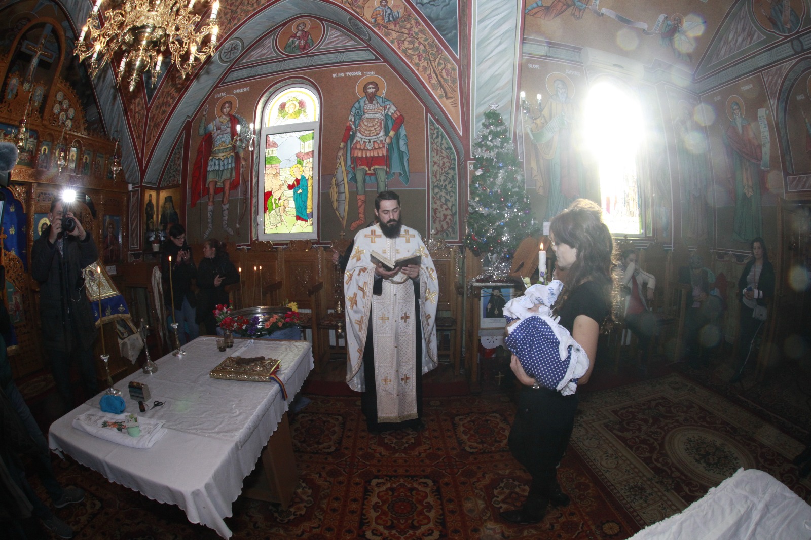 FOTO-REPORTAJ: Abandonat de mamă, s-a ales cu zeci de părinți spirituali. Bebelușul lăsat în ger a fost botezat