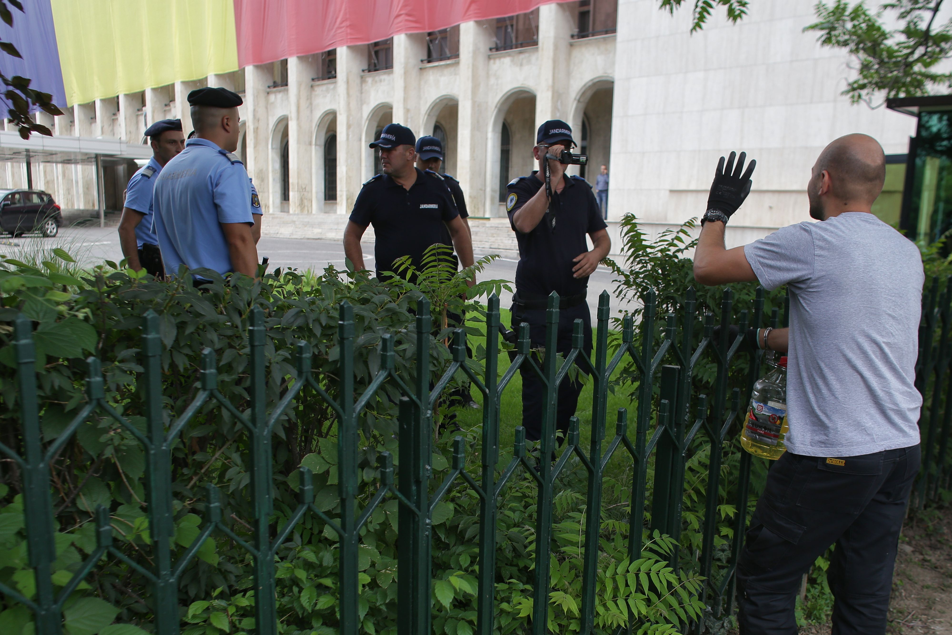 UPDATE. Bărbatul care s-a legat cu lanțul de gardul Guvernului și avea asupra lui o sticlă de benzină a fost descarcerat si ridicat de Jandarmerie (FOTO / VIDEO)