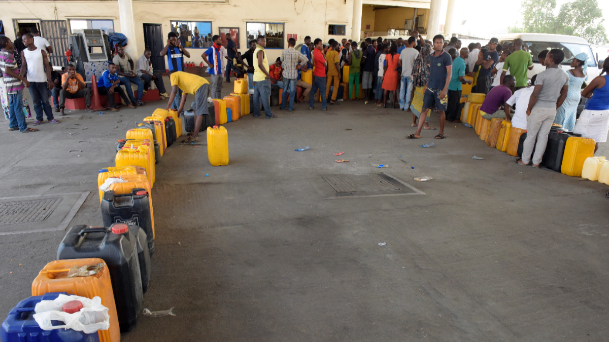 People stands to buy fuel with jerry cans at a filling station in Lagos, on December 1, 2015. [Getty Images]