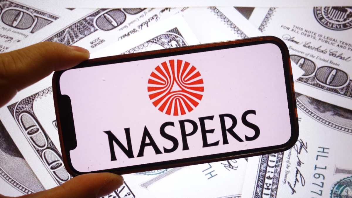 In this photo illustration, the Naspers company logo is seen displayed on a smartphone screen with United States dollar banknotes in the background. [Photo Illustration by Piotr Swat/SOPA Images/LightRocket via Getty Images]