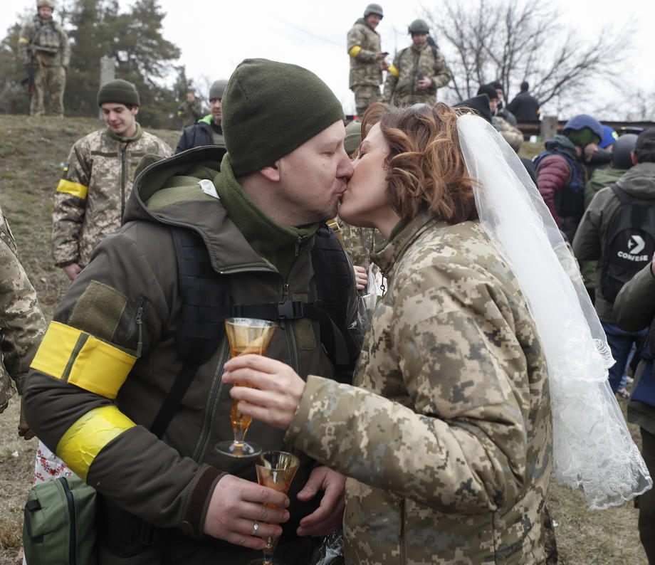 Nuntă pe front. În haine de camuflaj, cu alai înarmat cu flori și puști, doi militari ucraineni s-au căsătorit
