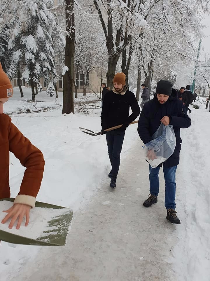 FOTO/ Studenții au ieșit să deszăpezească un trotuar de pe un bulevard din Timișoara pentru că s-au săturat să aștepte Primăria. Robu spune că s-a făcut "tot ce era omenește posibil"