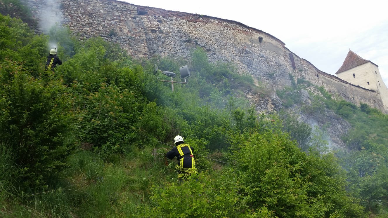 Incendiu de vegetaţie uscată lângă zidurile Cetății Râşnov. Pompierii au stins focul după o oră/ FOTO
