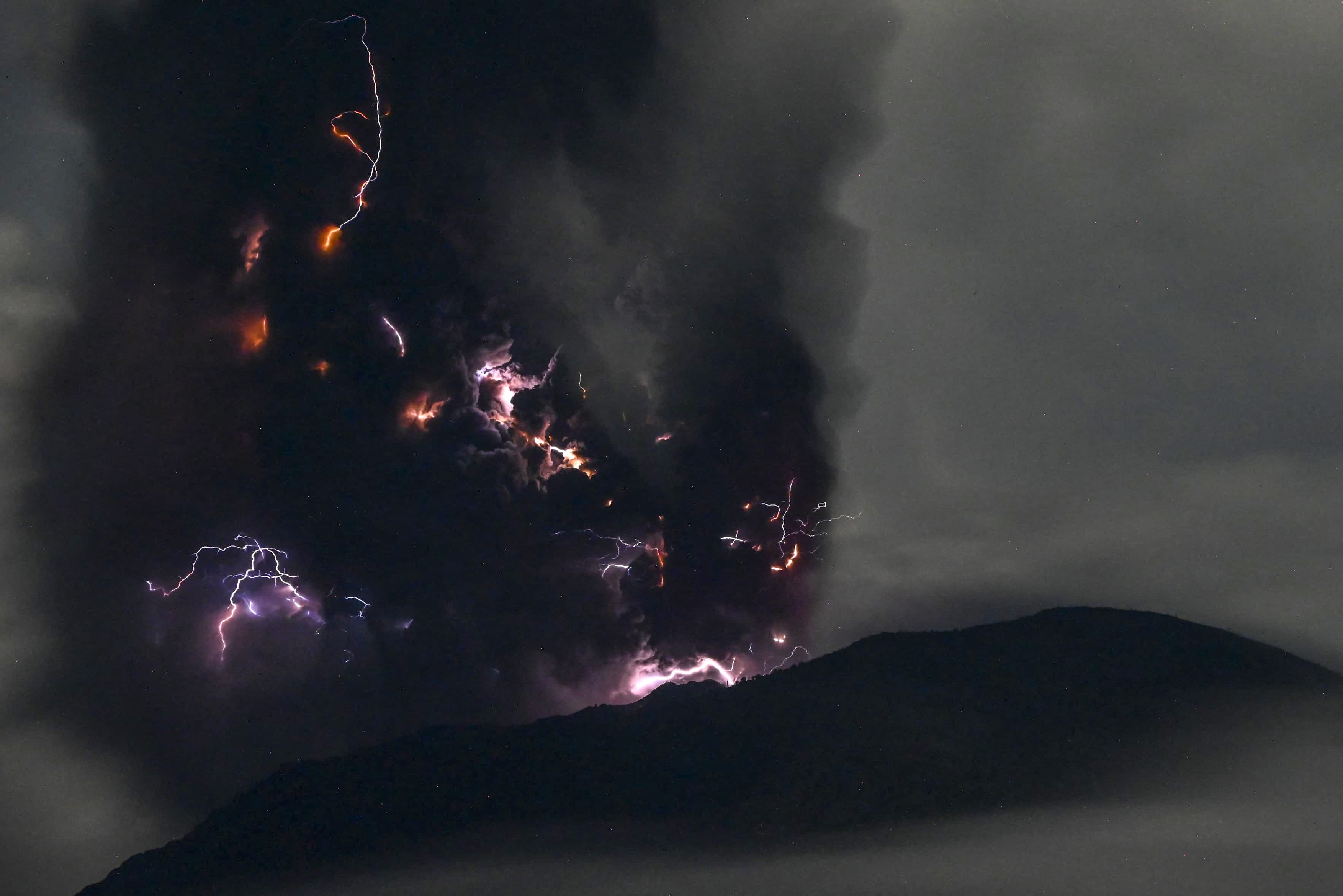 Erupție spectaculoasă a vulcanului Ibu din Indonezia. Fulgere violet în jurul craterului și coloane de cenușă ce se ridică la peste 4 km