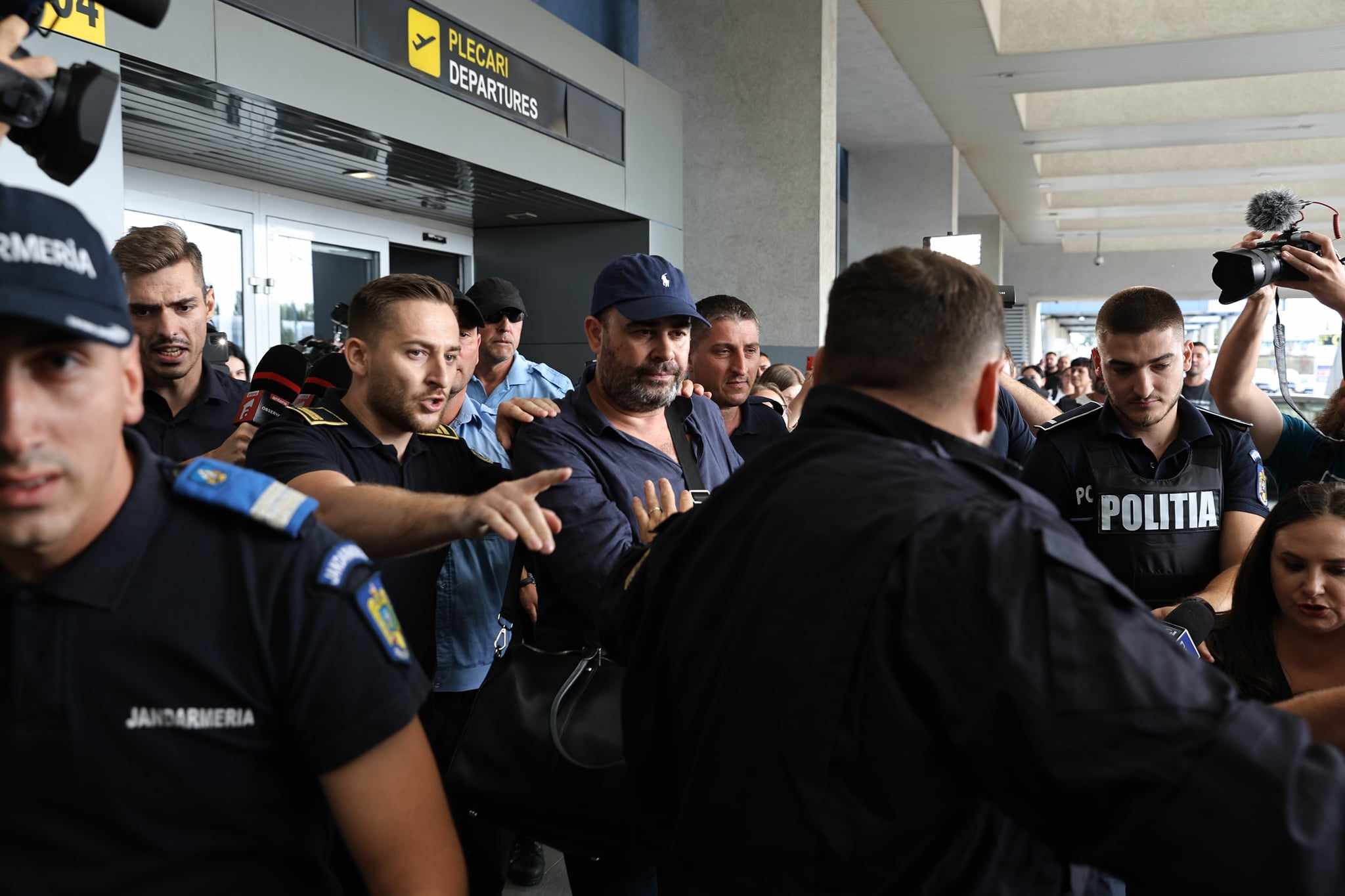 Darius Vâlcov, extrădat din Italia: flancat de jandarmi pe Otopeni, până la mașina care l-a dus la penitenciar. Are de ispășit o pedeapsă de 6 ani de închisoare