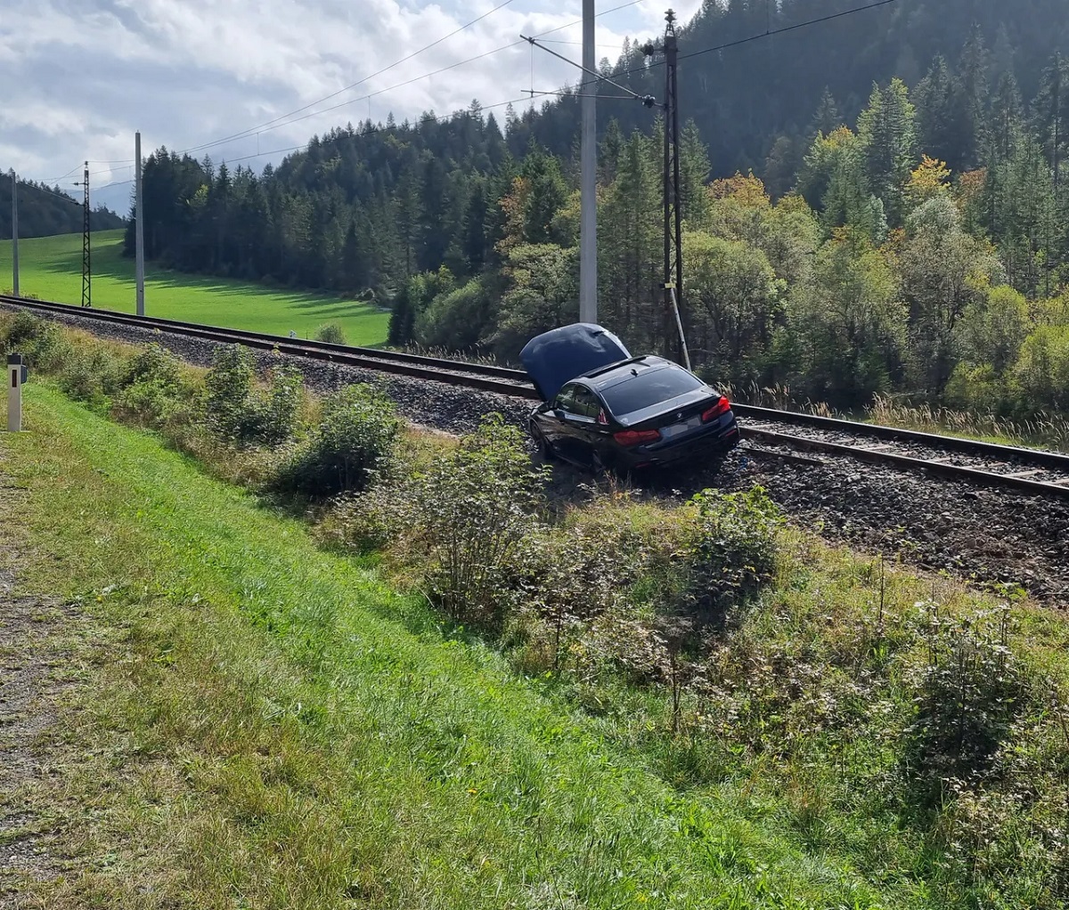Un român în vacanță cu soția și copilul de un an a ajuns cu BMW-ul pe calea ferată. A depășit într-o curbă și a răsturnat o rulotă, în Austria