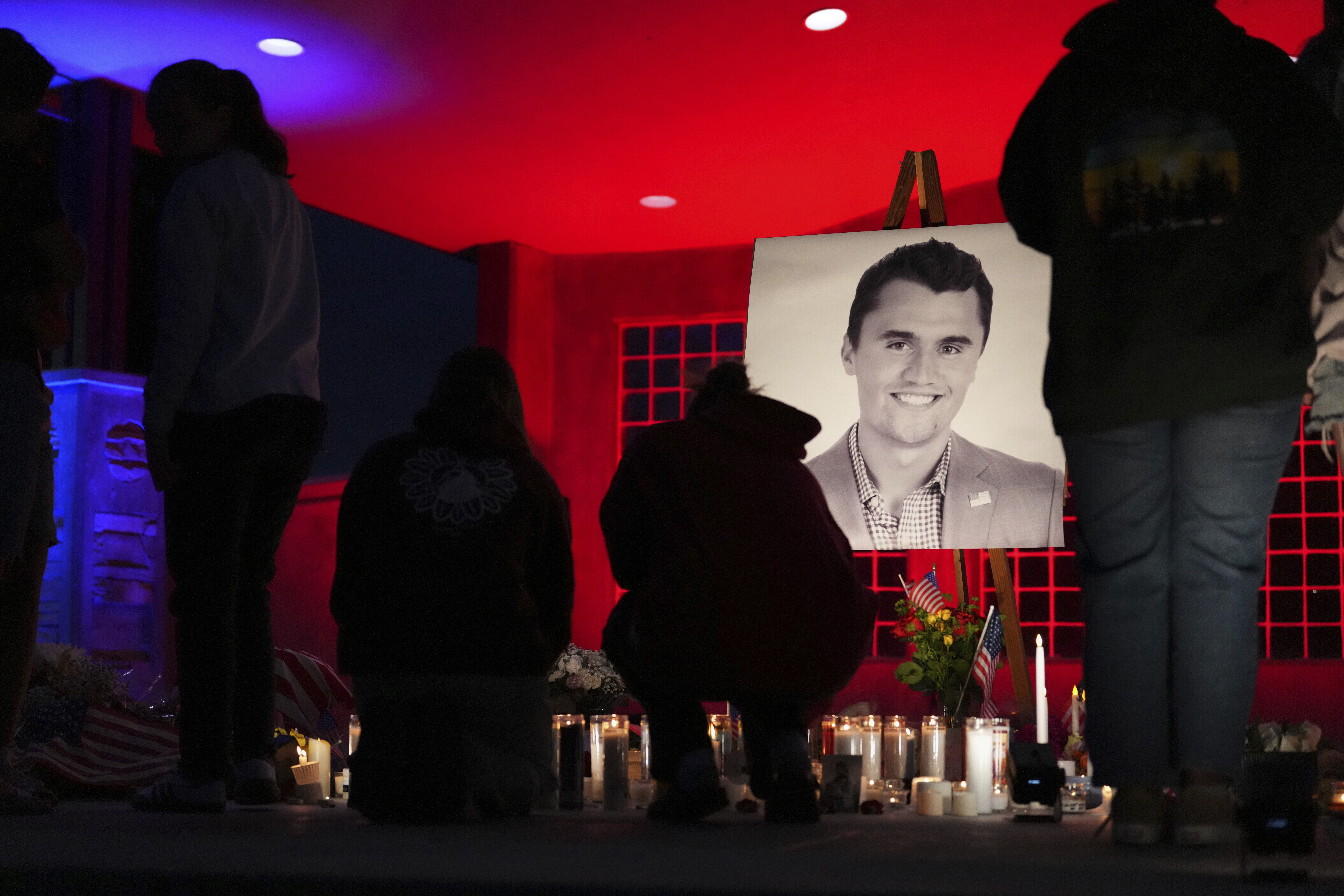 People place lit candles below a photo of Charlie Kirk, the CEO and co-founder of Turning Point USA who was shot and killed, at a vigil in his memory, Thursday, Sept. 11, 2025, in Orem, Utah.