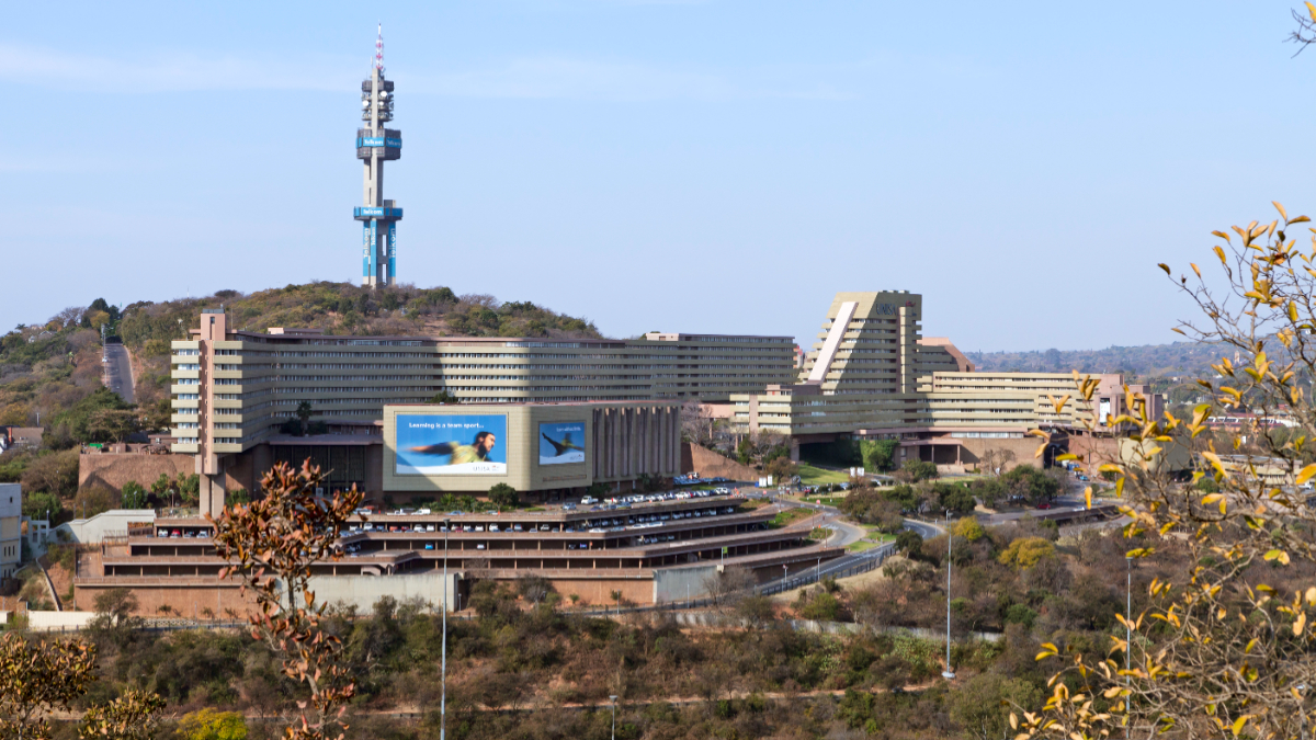 Pretoria, South Africa - July, 29th 2012: UNISA University of South Africa building, with Telkom telecommunications tower seen behind. Car parkade below the building. The main highway seen far below. [Stock Photo via Getty Images]