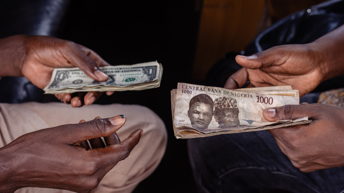 A customer exchanges Nigerian 1000 Naira banknotes for US dollar banknotes with a street currency dealer at a market in Lagos, Nigeria, on Monday, Sept. 25, 2023. [Photo: Benson Ibeabuchi/Bloomberg via Getty Images]