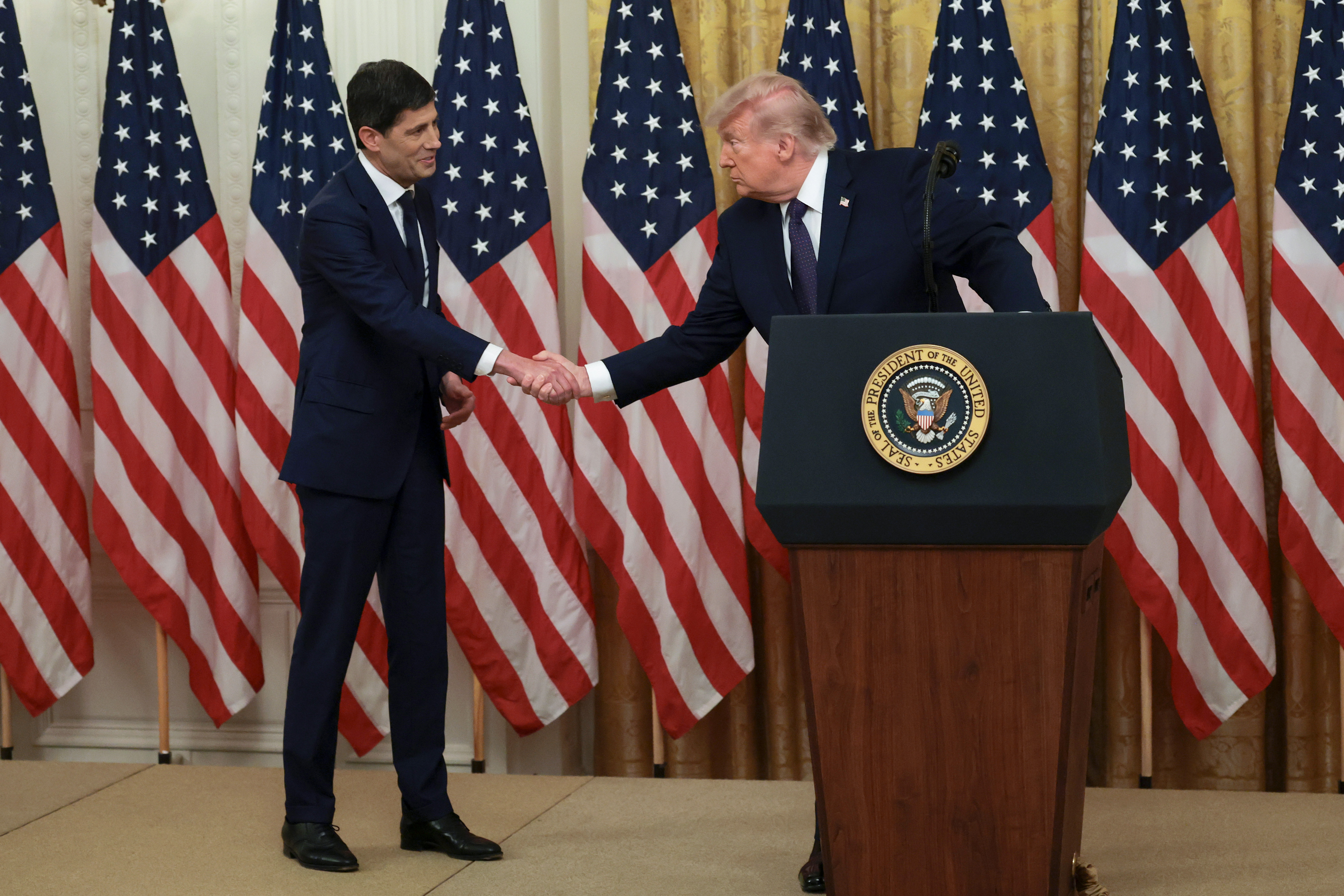 President Donald Trump shakes hands with Kevin Warsh as they arrive to Warsh's swearing-in ceremony to be the new Chairman of the Federal Reserve in the East Room of the White House on May 22, 2026, in Washington, D.C. 