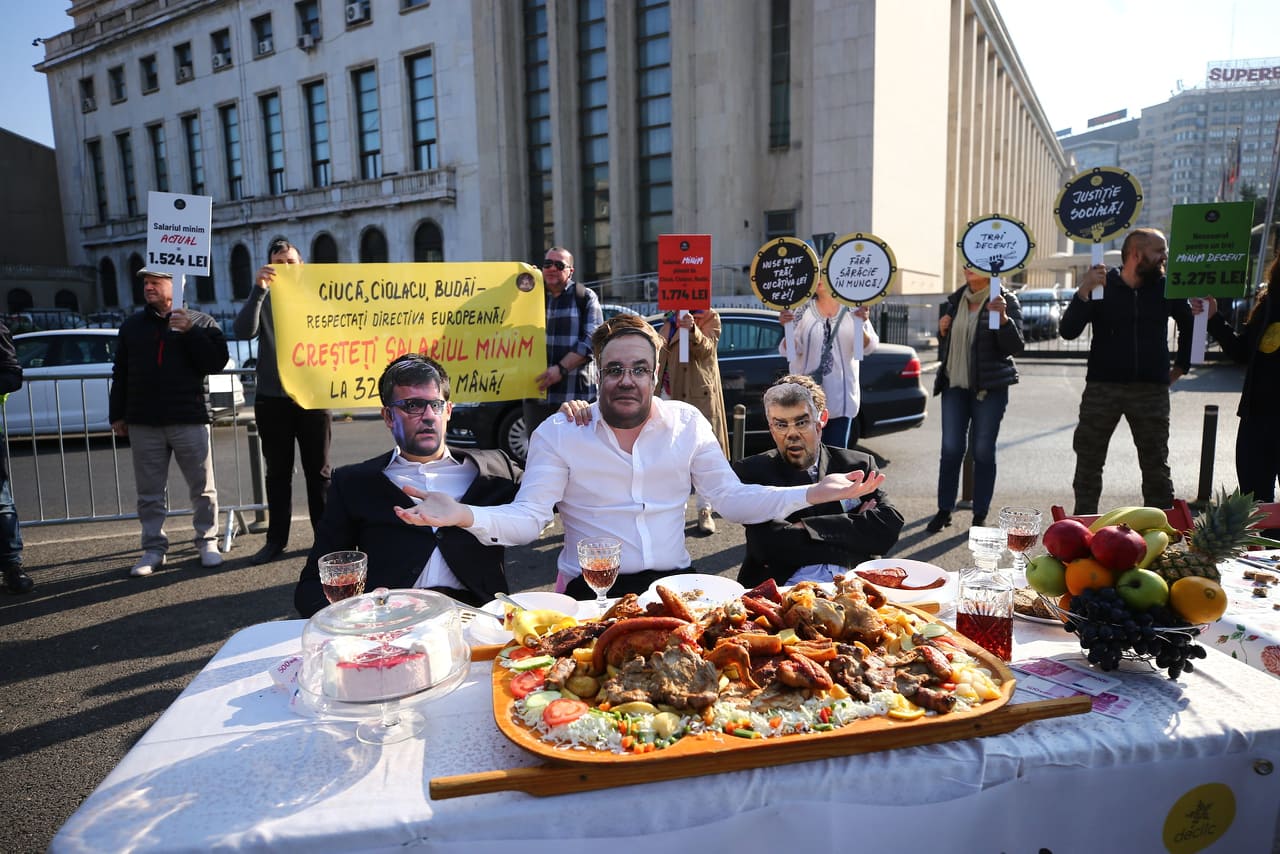 Protest în timpul ședinței de Guvern pe tema salariului minim european. „Ciucă”, „Ciolacu” și „Budăi” au luat masa în Piața Victoriei