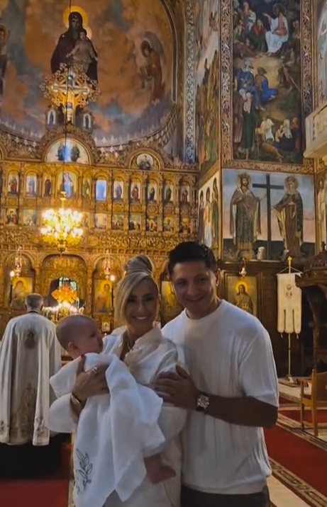 Anamaria Prodan și Ronald Gavril, în postura de nași de botez. Îmbrăcați în alb, au devenit părinții spirituali ai unui băiețel