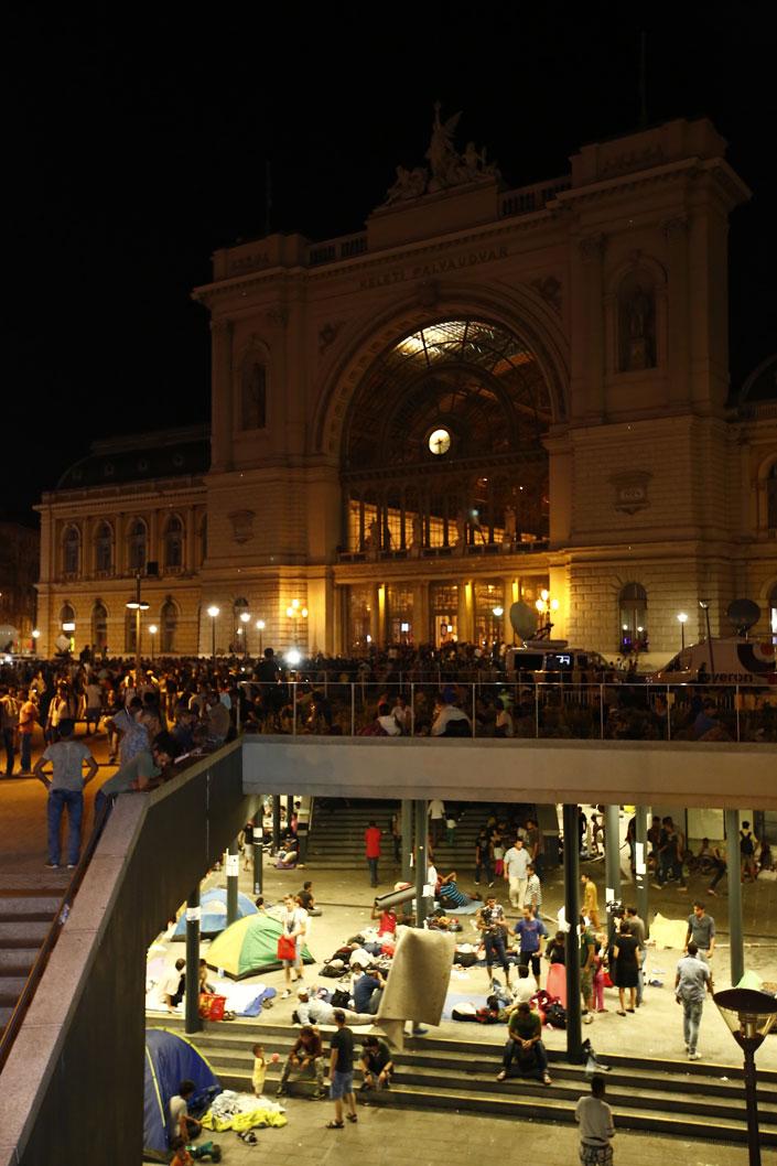 Corespondenţă din UngarIAD! Budapesta e sub asediul miilor de refugiați, iar autoritățile maghiare par să nu mai le facă față. ^Nu doar gara Keleti, epicentrul mulțimii care a venit să-și găsească un trai uman în Europa, e ocupată. Parcurile din jurul arenei pe care se va juca sunt pline de sirieni și de afgani. Nimic nu e ce pare, nimic nu mai e sigur. Se va juca și fotbal aici?