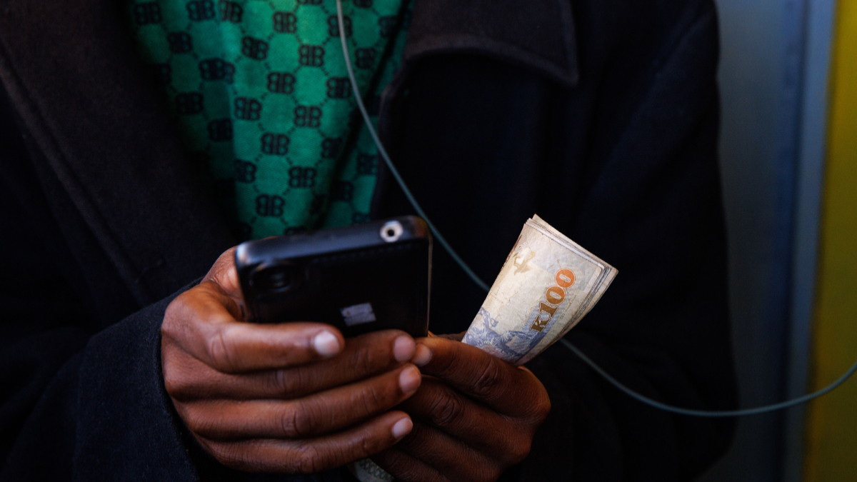 A mobile money vendor holds Ghana cedi banknotes in Kumasi, Ghana, on Saturday, May 11, 2024. Ghana's cedi has declined 14% this year, a slump beaten only by currencies that have been devalued, including the Egyptian pound and Nigerian naira. [Photo: Ernest Ankomah/Bloomberg via Getty Images]
