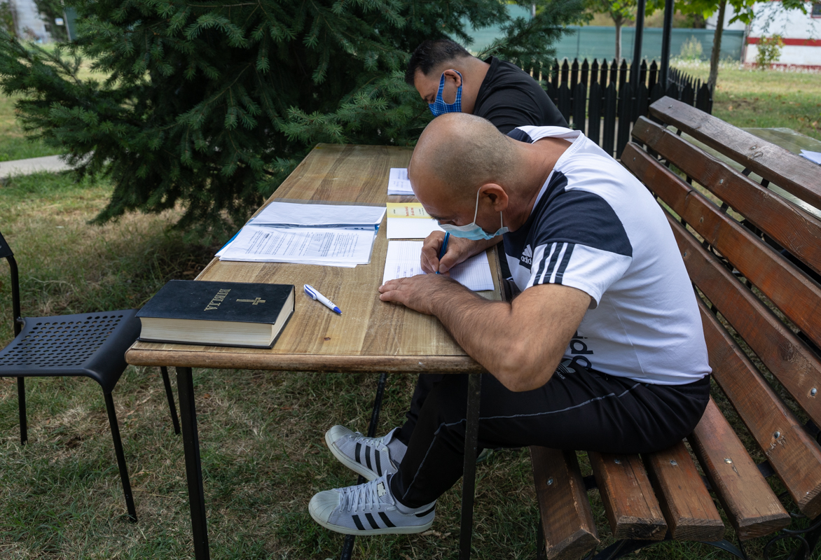 Preotul care îi învață alfabetul pe deținuții de la Jilava și le dă teme de făcut în celulă. „Daniel scrie cel mai frumos, așa îmi pare mie”