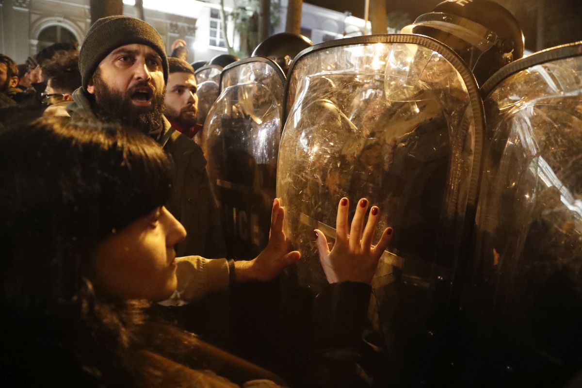 Imagine simbolică pentru 2023, la protestele din Georgia: manifestanți strânși în jurul steagului UE, fluturat de o femeie pe care autoritățile au pus tunul cu apă - VIDEO