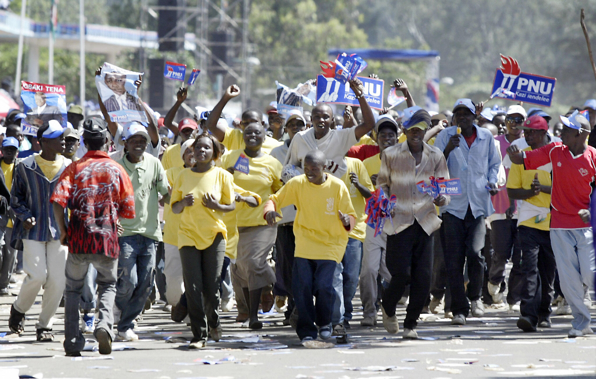 Supporters of Kenyan President and presidential candidate Mwai Kibaki run while chanting his name during a rally in downtown Nairobi, Kenya 24 December 2007. Some fourteen million voters will go to the polls on 27 December to elect a new President, 210 members of parliament and more than 2,000 local councillors.  [Photo by ROBERTO SCHMIDT/AFP via Getty Images]