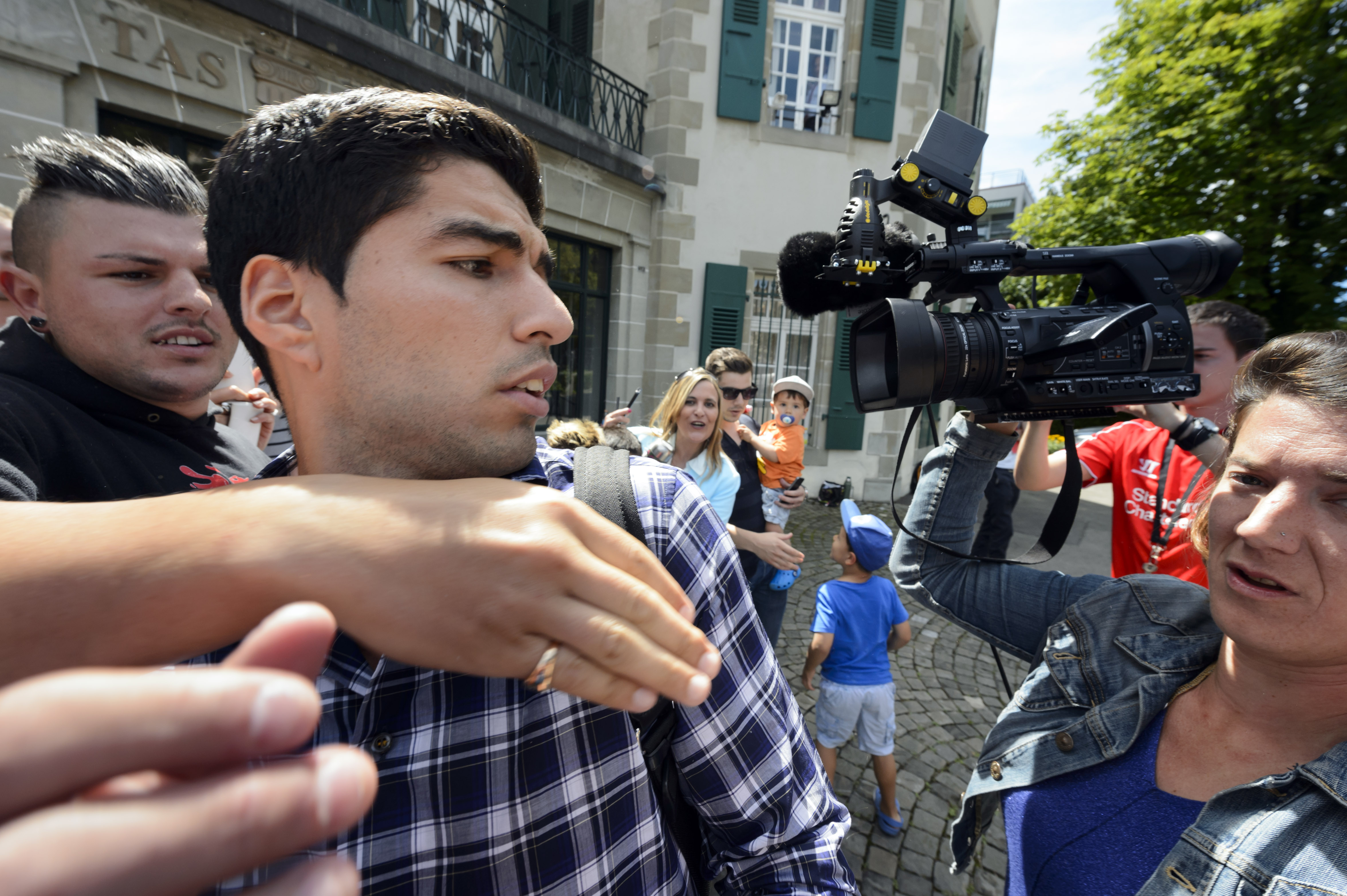 GALERIE FOTO / Luis Suarez provocat să muşte din nou, un fan i-a băgat mâna în gură